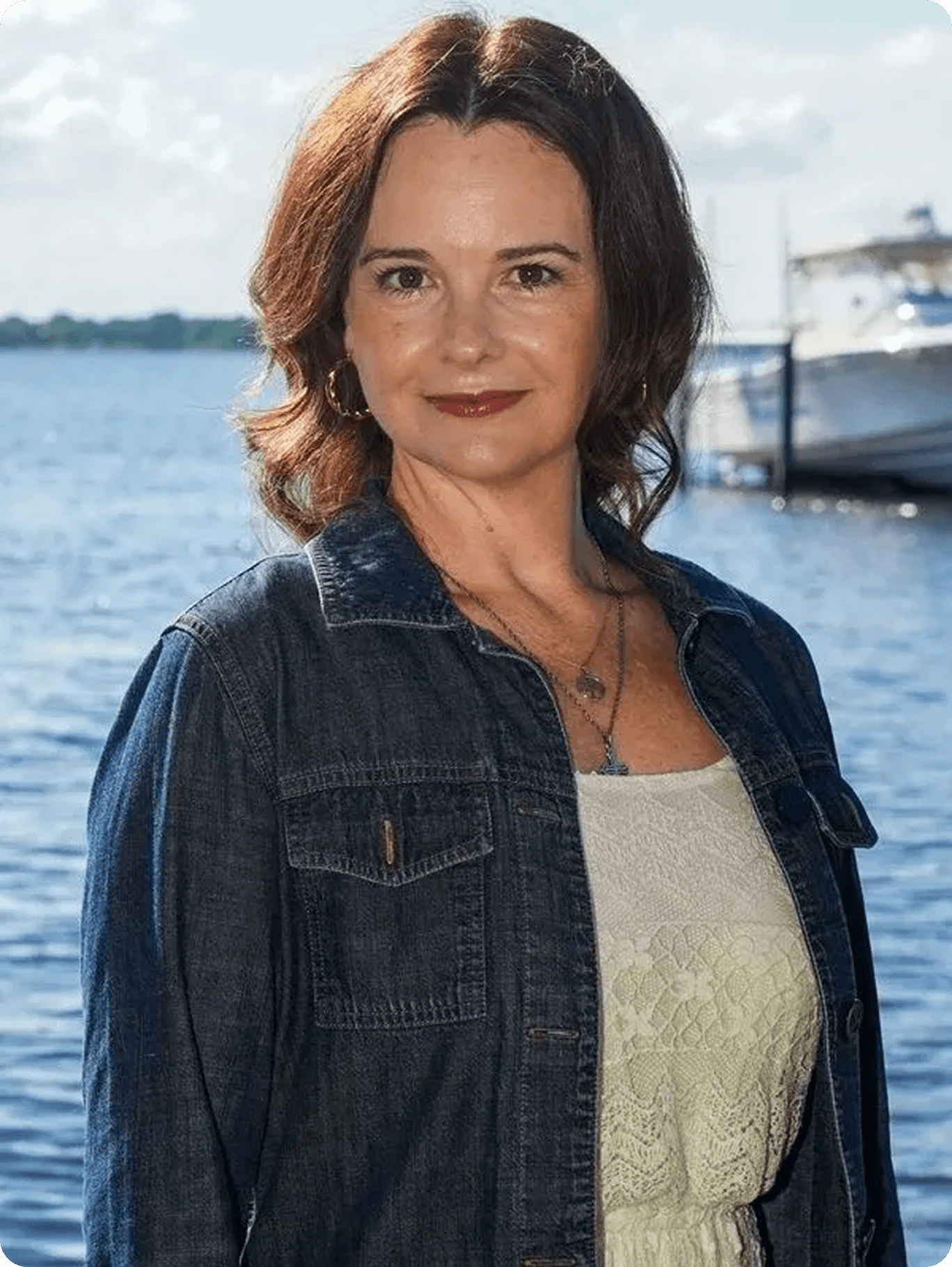 Smiling woman with boat in background